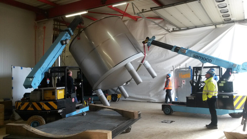 Barry Callebaut - Halle - lifting tank inside building with 2 electrical cranes